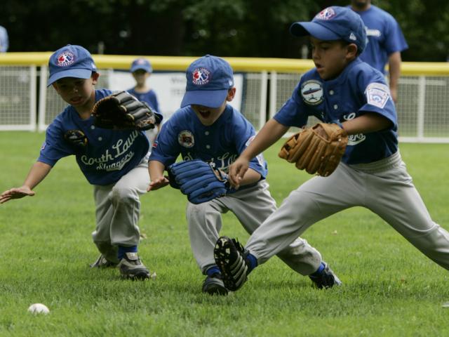 Outfielders for the Dolcom Little League Indians dive for the ball on the South Lawn of the White House during action in the opening game of the 2006 Tee Ball season, June 23, 2006. (P062306-0168)