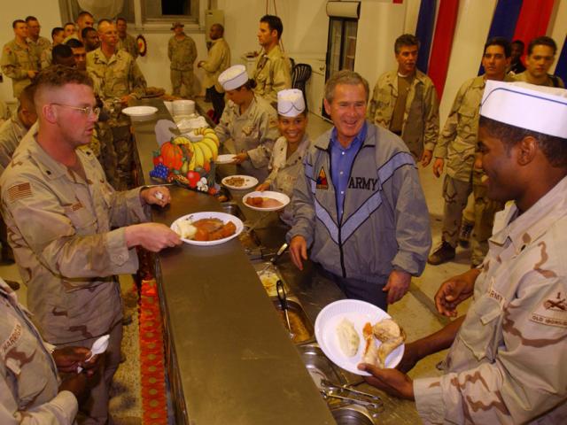 President George W. Bush meets with troops and serves Thanksgiving dinner at the Bob Hope Dining Facility, Baghdad International Airport, Iraq, on November 27, 2003. (P36047-34)