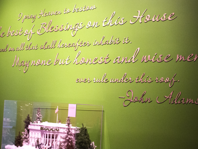 A photo of a quotation from John Adams, 'I pray heaven to best the best of Blessing on the House and on all that shall hereafter inhabit it. May none but honest and wise men ever rule under this roof,' at the gallery entrance to the 2017 Holiday exhibit at the George W. Bush Library and Museum