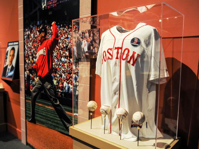 A picture of a display featuring a Boston Red Sox uniform jersey and baseballs, part of the 2015 exhibit 'Baseball: America's Presidents, America's Pastime,' at the George W Bush Library and Museum