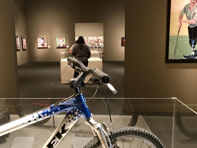 A photo of the 2017 exhibit Portraits of Courage, at the George W Bush Library and Museum with a Trek bicycle display in the foreground
