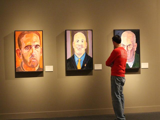 A photo of a visitor looking at portraits by President George W Bush, part of the 2017 exhibit Portraits of Courage, at the George W Bush Library and Museum