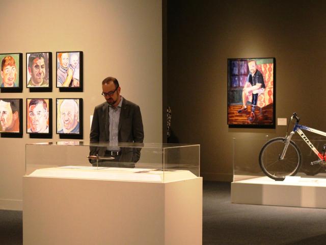 A photo of a visitor looking at a display in the 2017 exhibit Portraits of Courage, at the George W Bush Library and Museum