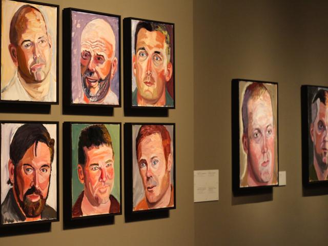 A photo of a wall filled with portraits painted by President Bush, part of the 2017 exhibit Portraits of Courage, at the George W Bush Library and Museum