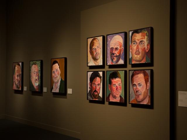 A photo of a wall of portraits painted by President George W Bush on display on a wall, part of the 2017 exhibit Portraits of Courage at the George W Bush Library and Museum