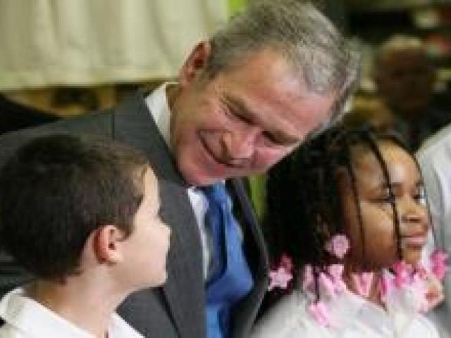 President George W. Bush talks with sixth grade student Mariano Ramos, 11, left, and seventh grader Amber McCarthy, 12, during a visit to the Horace Greeley Elementary School in Chicago on January 7, 2008.