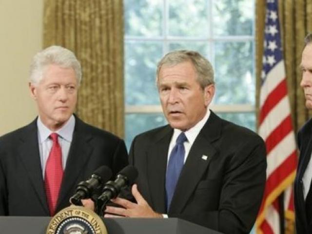 Standing with former Presidents Bill Clinton and George H. W. Bush, President George W. Bush discusses the plans to help people affected by Hurricane Katrina in the Oval Office on September 1, 2005.