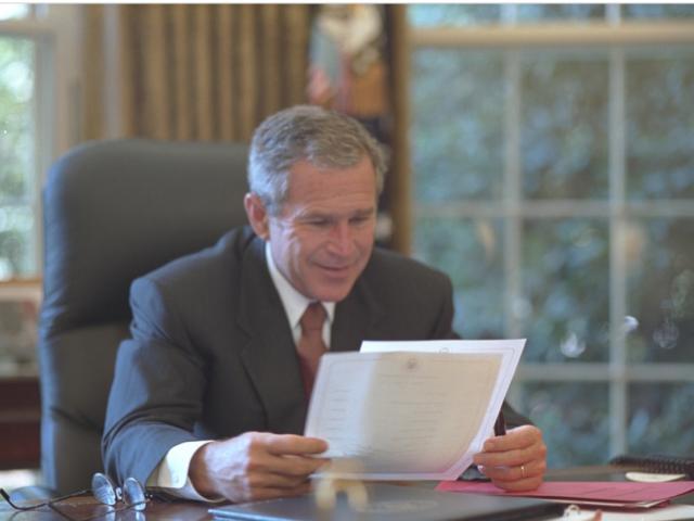 President George W. Bush reviews his schedule in the Oval Office on September 13, 2001.