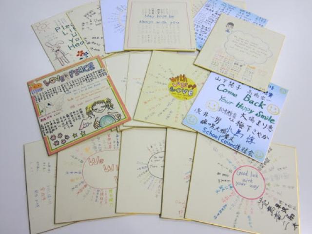 Students from homeroom classes at this school in Japan draw pictures and sign their names on wooden boards with gold painted trim.