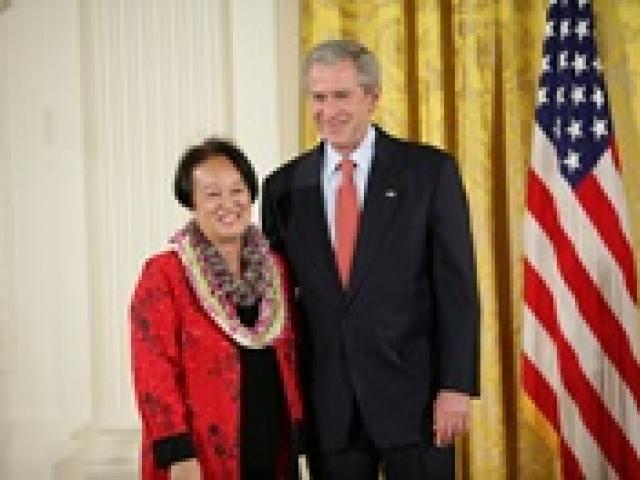 President George W. Bush welcomes Linda Uehara of Mililani, Hawaii, to the stage in the East Room of the White House, to receive the President’s Volunteer Service Award on May 10, 2007 