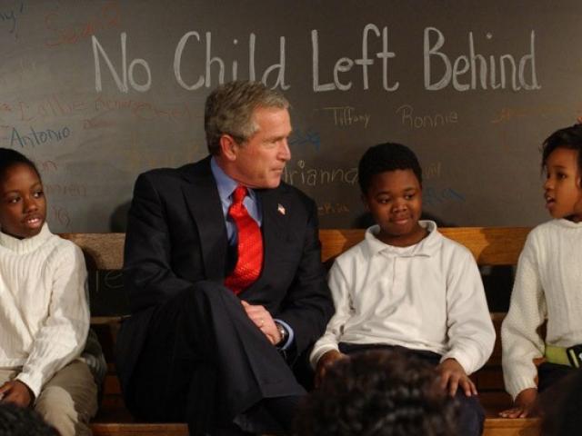 President Bush sits with students on a bench