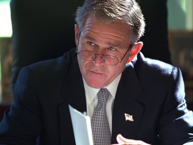 President George W. Bush reads a briefing in the Oval Office of the White House.